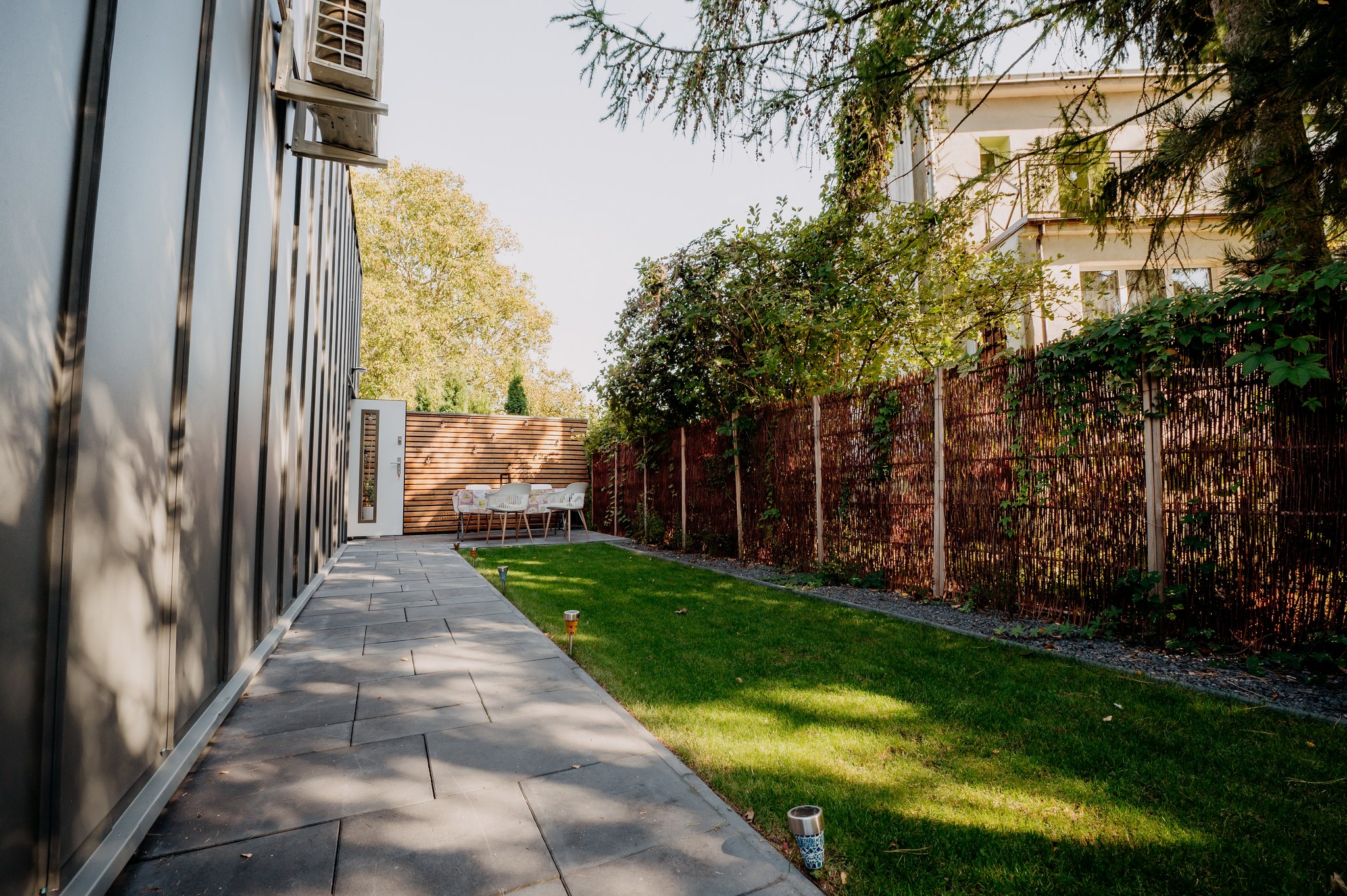 white and brown house near green grass field and body of water during daytime